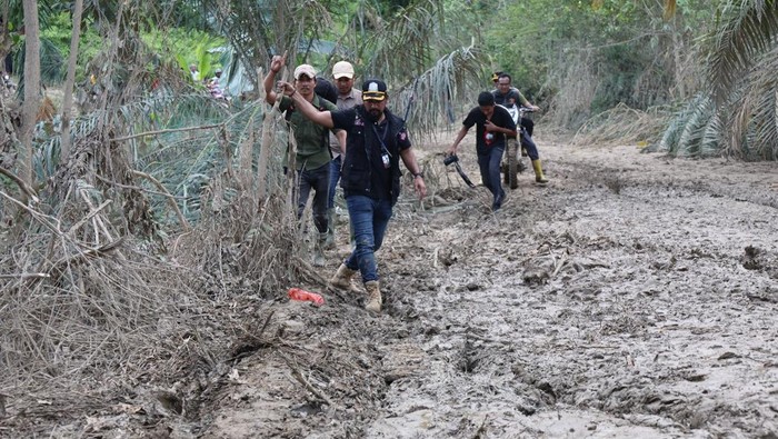 1765645548977-rombongan-bupati-aceh-timur-iskandar-usman-al-farlaky-berjalan-kaki-melewati-jalan-berlumpur-untuk-menuju-ke-lokasi-bencana-do-1765623756536_169